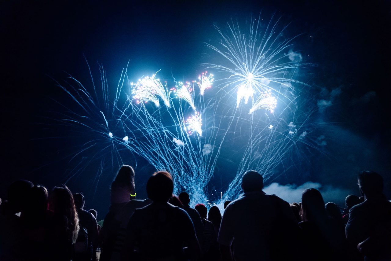 Feuerwerk über einer Menschenmenge bei Nacht